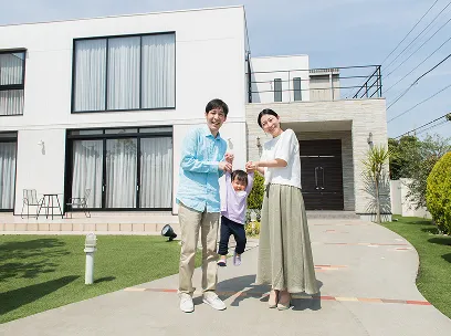 戸建ての前で家族が楽しそうに過ごす様子。