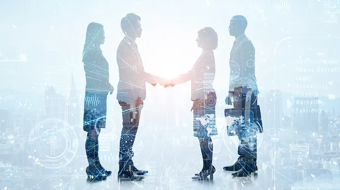 ビジネスパーソン同士が握手し、周囲にデジタルネットワークのエフェクトが重なる連携イメージの写真。